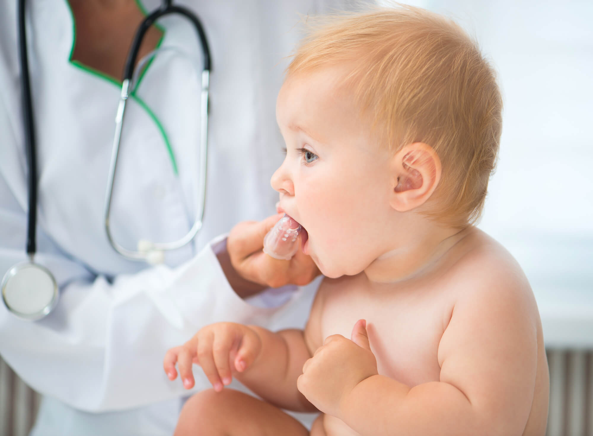 pediatric dentist in Coral Gables cleaning a baby's teeth